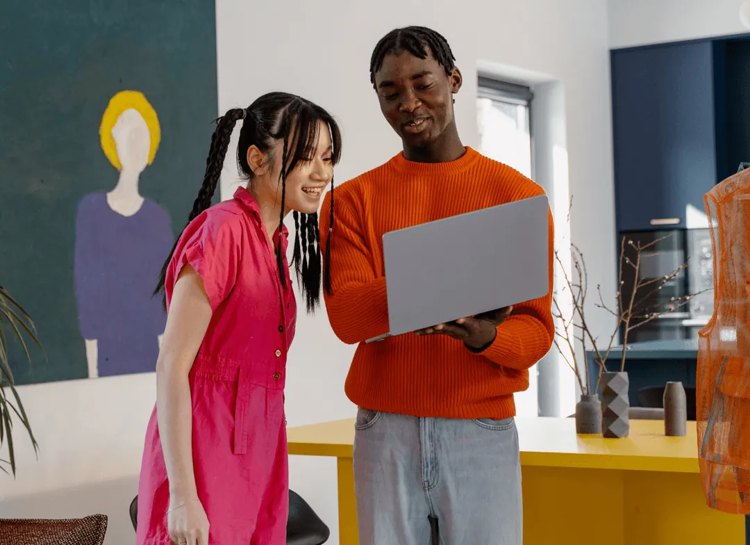 Two creators reviewing a laptop together