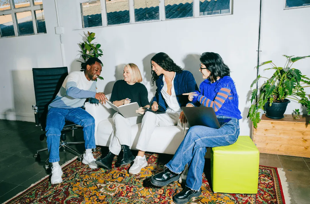 A team reviewing work together on a sofa